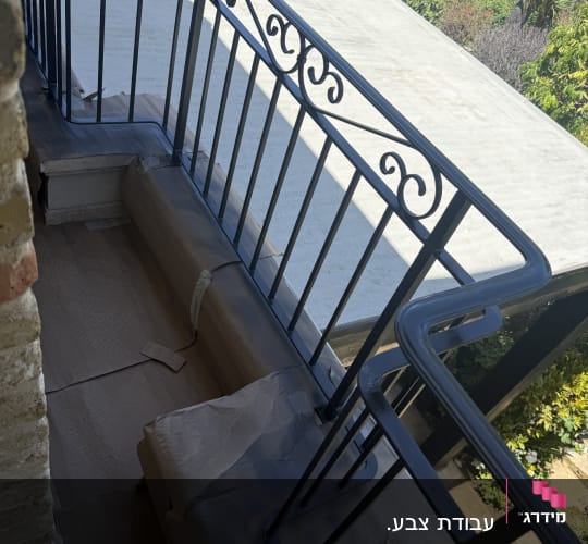 מעקה מרפסת צבוע עם ניירות הגנה על הרצפה